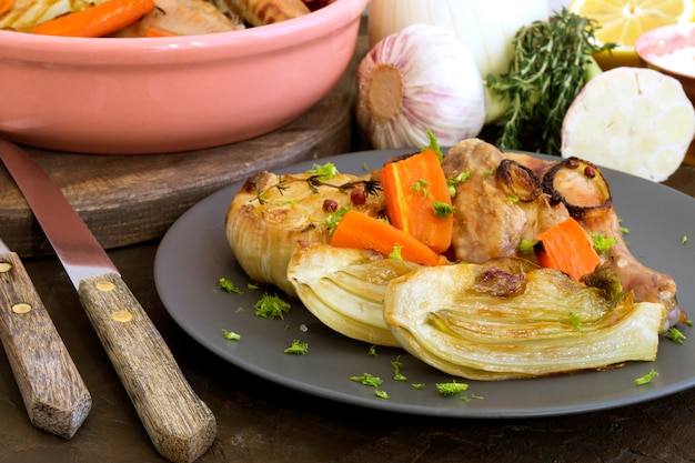 Pollo Frito Con Verduras. en un plato gris.