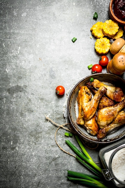 Pollo frito con verduras y salsa de tomate sobre un fondo de piedra