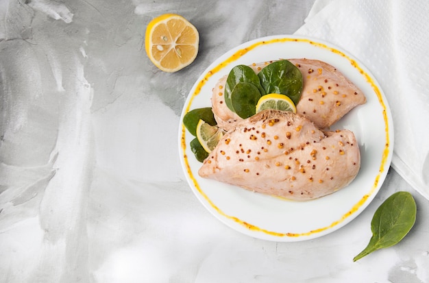 Pollo hervido con limón y albahaca en un plato