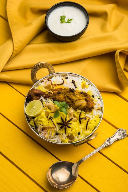 Pollo Hyderabadi o dum biryani, servido en un Kadhai o tazón con salsa de yogur. enfoque selectivo