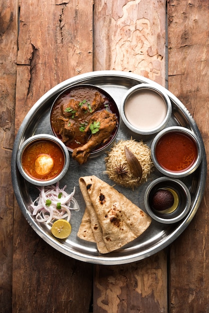 El pollo Kolhapuri Thali es un popular plato de comida asiática de la India que consiste en carne de ave, huevo al curry con chapati, arroz, ensalada y dulce Gulab Jamun.