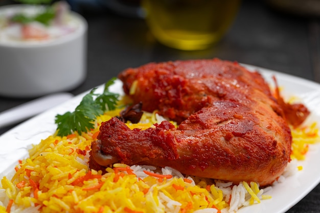 Pollo Mandi Biryani dispuestas en una loza con fondo negro o textura