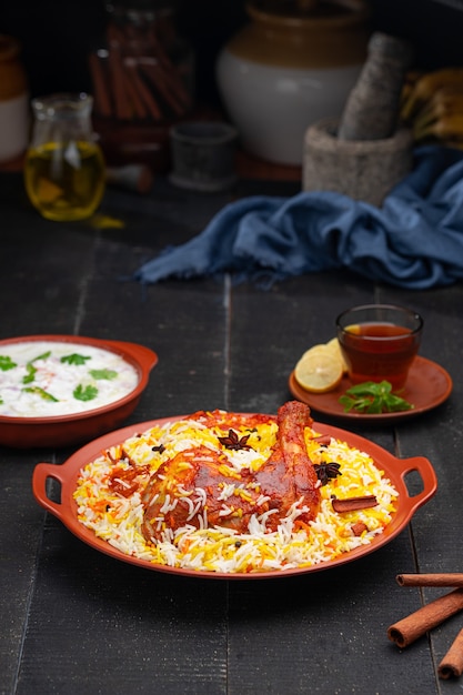 Pollo Mandi Biryani con raita como guarnición dispuesta en una loza