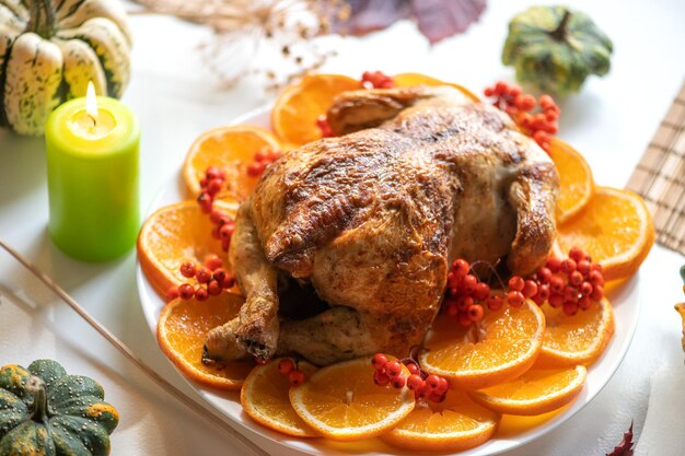 Foto pollo o pavo entero horneado para navidad mesa de acción de gracias con decoración pollo asado casero vino y ensalada de frutas fondo bokeh