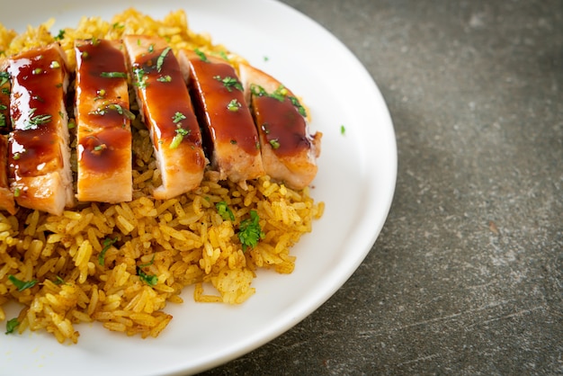 Pollo a la parrilla dulce y guindilla con arroz al curry en la placa