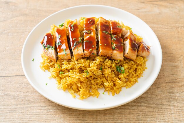 Pollo a la parrilla dulce y guindilla con arroz al curry en la placa