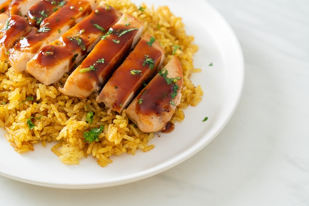 Pollo a la parrilla dulce y guindilla con arroz al curry en la placa