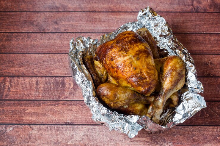 Pollo a la parrilla muy asado sobre fondo de madera
