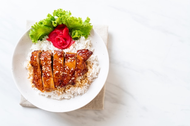 pollo a la parrilla con salsa teriyaki sobre arroz cubierto