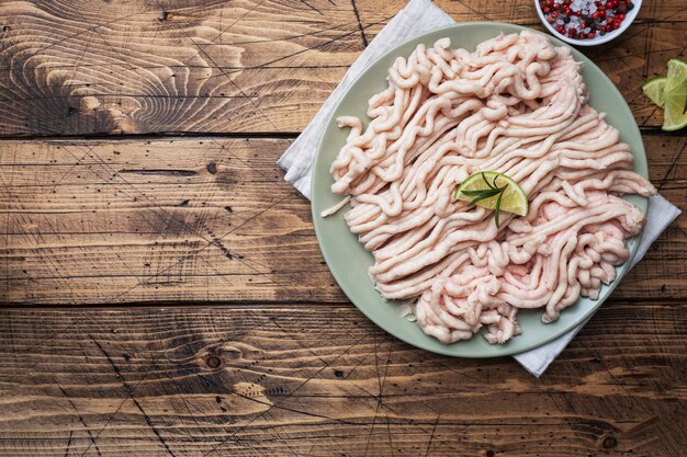 Pollo picado crudo en un plato con especias y limón.