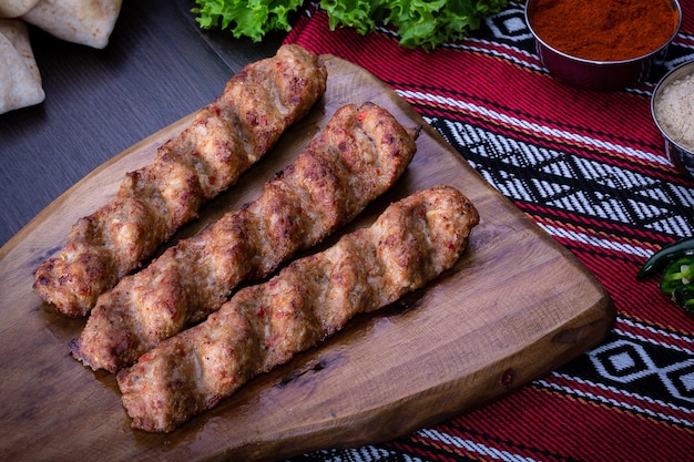 Pollo picante seekh Kebab servido en tablero de madera aislado en la vista superior de la mesa de comida árabe