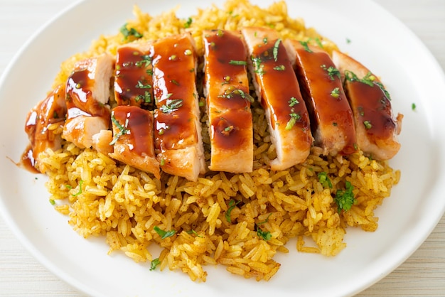 Pollo a la plancha dulce y guindilla con arroz al curry en la placa