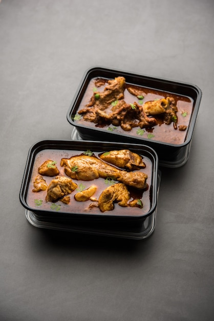 Pollo rojo al curry y cordero Masala envasados en un recipiente de plástico para la entrega