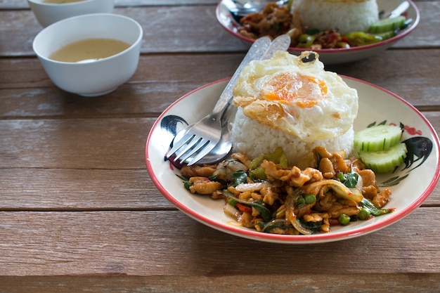 Pollo salteado tailandés y albahaca servido con arroz y huevo frito, la comida favorita de Tailandia.