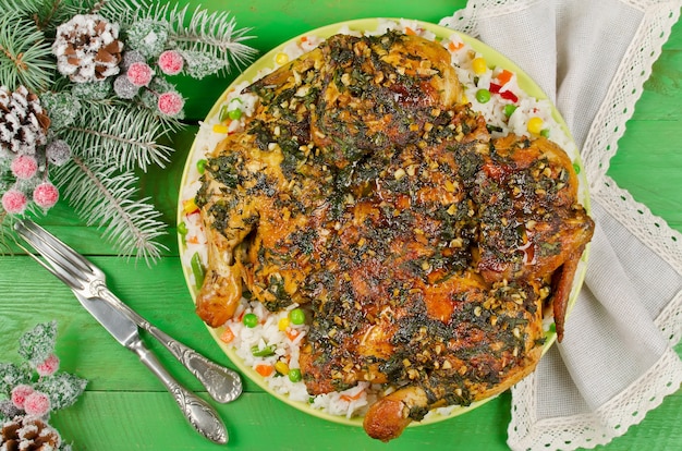 Pollo Tabaka adorne el arroz con verduras en la mesa de madera