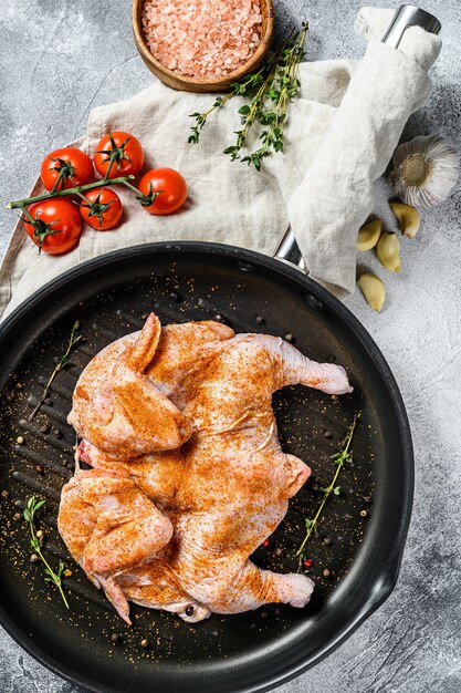 Pollo tabaka crudo en sartén