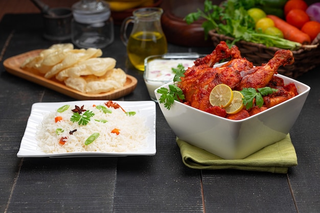 Pollo Tandoori picante adornado con hojas de cilantro en un tazón blanco de forma cuadrada