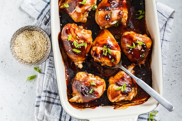 Pollo teriyaki al horno con cebolla verde y semillas de sésamo, vista desde arriba.