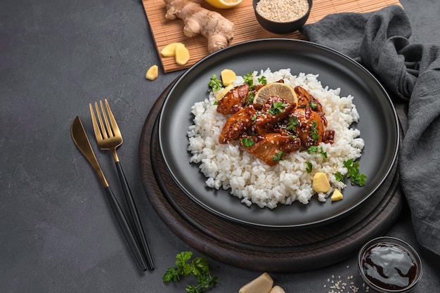 Pollo teriyaki con arroz sobre un fondo oscuro