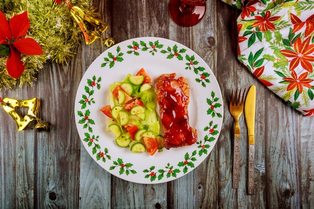 Pollo teriyaki con ensalada fresca en mesa decorada de Navidad