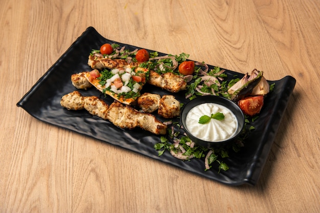 Pollo tikka boti kabab con ensalada y salsa de mayonesa servido en un plato aislado en la mesa vista superior de comida árabe