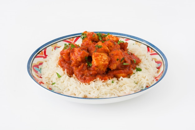 Pollo tikka masala con arroz aislado en blanco