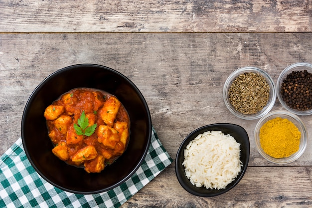 Pollo tikka masala en un tazón sobre mesa de madera