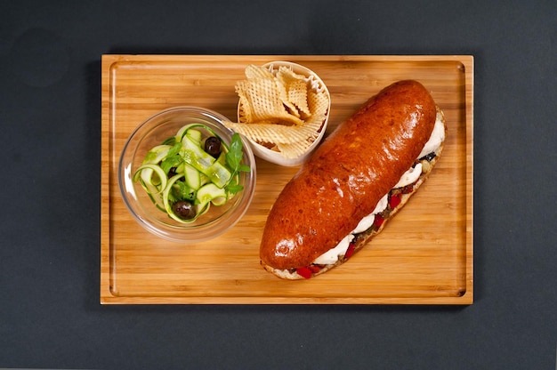 Foto pollo vienés con plato de madera y ensalada