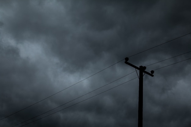 Polo eléctrico y cielo oscuro antes de la lluvia