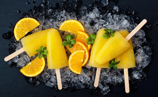 Polo de hielo de naranja de frutas y rodajas de naranja