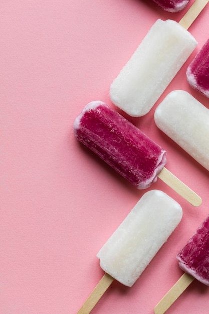 Polos de hielo de verano rosa y blanco sobre un fondo rosa