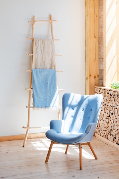 Foto poltrona macia e confortável no apartamento loft ecológico escandinavo. sala de visitas minimalista moderna com pilha de lenha.