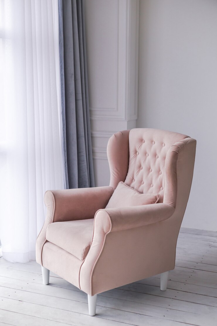 Poltrona rosa na sala de estar perto da janela.