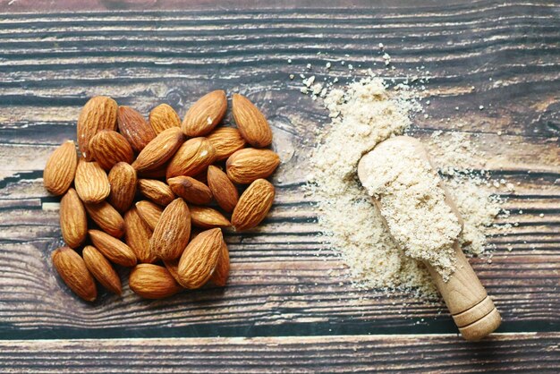 Polvo de almendras y almendras en la vista superior de la mesa de madera