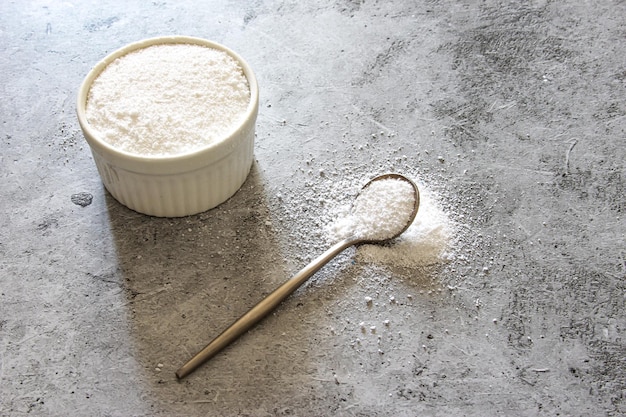 Foto polvo de colágeno sobre fondo gris suplemento de salud natural para la piel