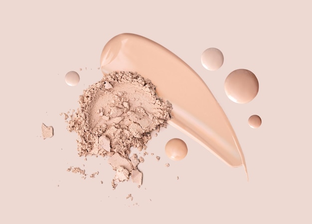 Polvo de crema de base de frotis cosmético sobre un fondo beige