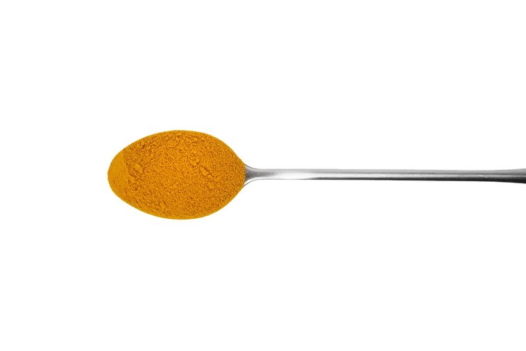 Polvo de cúrcuma en una cuchara aislada en la vista superior de fondo blanco Especia de cúrcuma