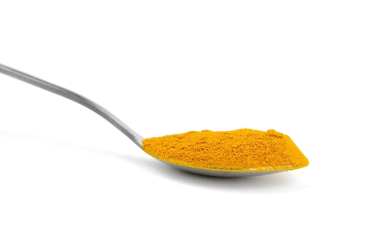 Polvo de cúrcuma en cuchara aislado sobre fondo blanco especia de cúrcuma