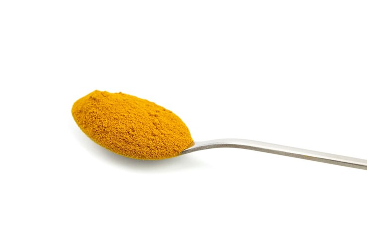 Polvo de cúrcuma en cuchara aislado sobre fondo blanco