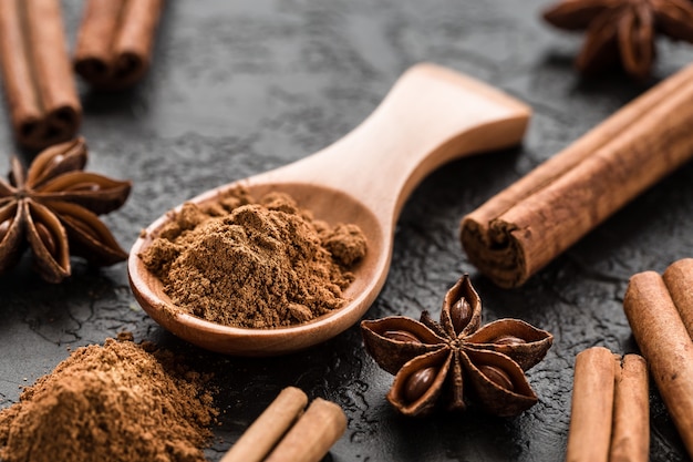 Polvo de especias de canela molida en una cuchara de madera