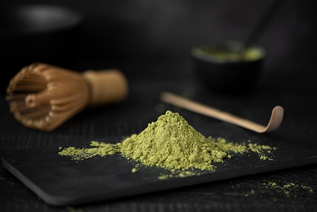 Foto polvo de matcha verde en tablero negro