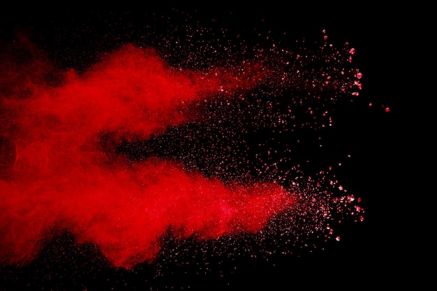 El polvo rojo abstracto salpicó en fondo negro. Explosión de polvo rojo.