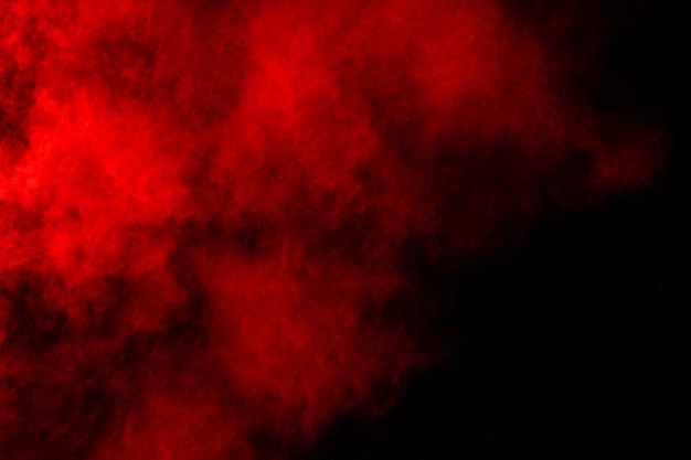 Polvo rojo abstracto splatted sobre fondo negro.