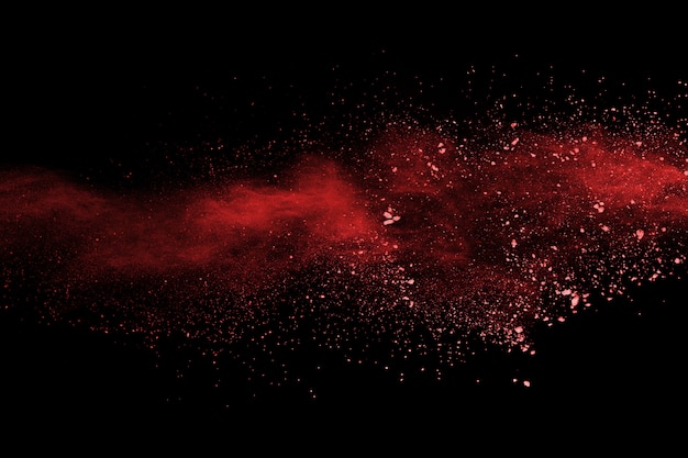 Foto polvo rojo abstracto splatted sobre fondo negro.