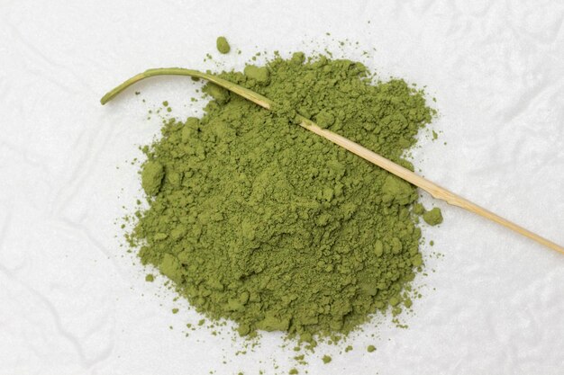 Polvo verde matcha y cuchara dosificadora de bambú para hacer té verde matcha