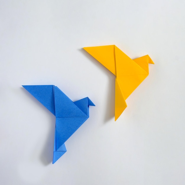 Pombas de origami japonesas de paz conceito amarelo e azul de paz e ajuda no conflito na Ucrânia e pôster de papel de hobby e entretenimento