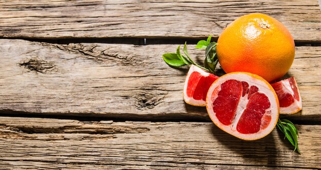 Pomelo fresco con hojas. Sobre una mesa de madera. Espacio libre para texto. Vista superior