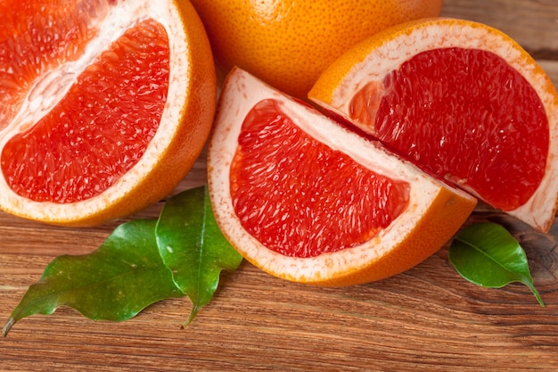 Pomelo con rodajas en una mesa de madera.