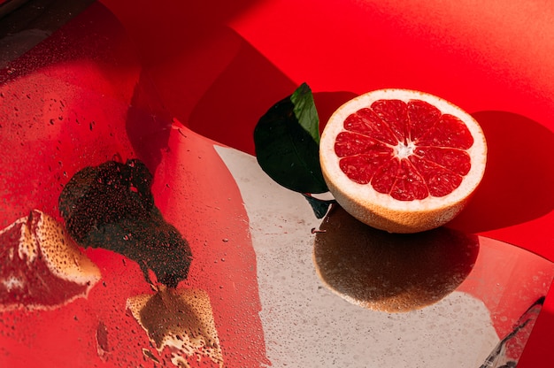 Pomelo rojo fresco en la superficie del espejo de reflexión