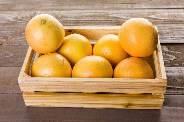 Pomelo rojo rubí fresco en caja de madera.